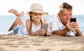 Smiling kids on beach with phone in hands Royalty Free Stock Photo