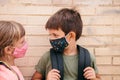 Portrait of two preschool kids with face masks outside school during Coronavirus Royalty Free Stock Photo