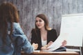 Portrait of two prett young women sitting at work desk. Royalty Free Stock Photo