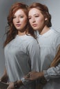 Portrait of two red-haired ethnic twin girls with a smartphone and a sheaf of wheat.