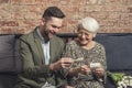 portrait of two relatives bonding and laughing while looking at old vintage photographs that belong to elderly woman Royalty Free Stock Photo