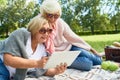 Two Senior Women Using Tablet in Park Royalty Free Stock Photo