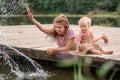 Portrait of two sisters children playing near the water on the background of the lake and the forest. The concept of a happy Royalty Free Stock Photo