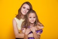 Portrait of two sisters on a yellow background 1