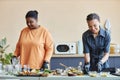 Two smiling African American women cooking together Royalty Free Stock Photo