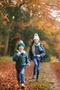 Portrait Of Two Smiling Children Having Fun Running Along Path Through Autumn Woodland Together Royalty Free Stock Photo