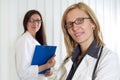 Portrait of Two Smiling Confident Female Doctors Looking at Camera Over White Background Royalty Free Stock Photo