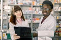 Portrait of two smiling friendly multiethnical pharmacists working in modern farmacy Royalty Free Stock Photo