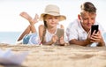 Smiling kids on beach with phone in hands Royalty Free Stock Photo