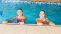 Portrait of two smiling teenage girls in swimming in pool. Family having fun and relaxing in water at summer holiday Royalty Free Stock Photo