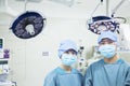 Portrait of two surgeons wearing surgical masks in the operating room, looking at camera Royalty Free Stock Photo