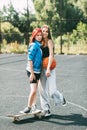 Portrait of two teenage girls with a basketball and a skateboard on a sports field Royalty Free Stock Photo
