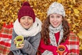 Portrait of two teenagers in a cozy hat and scarf girl and boy worm by tea from cups