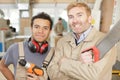 Portrait two tradesmen holding saw and drill