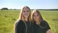 Portrait of two twin sisters in the field on a warm summer day Royalty Free Stock Photo