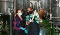 Two winemakers checking winemaking process at factory Royalty Free Stock Photo
