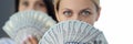 Portrait of two women holding fan of 100 dollar bills in front of their face Royalty Free Stock Photo