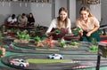 Portrait of two women playing with slot car racing track Royalty Free Stock Photo