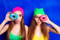 Portrait of two women pouting and holding donutes near eye Royalty Free Stock Photo