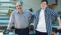 Portrait of two workers, standing in workshop, smiling and looking at camera Royalty Free Stock Photo