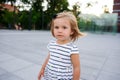 Portrait of a two year old girl in a striped dress.
