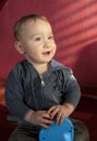 Portrait of a two years old boy sitting on the floor and smiling Royalty Free Stock Photo