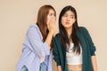 Portrait of two young women against plain wall Royalty Free Stock Photo