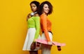 Two young beautiful hipster girls in trendy colorful summer clothes Royalty Free Stock Photo