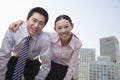 Portrait of two young business people leaning forward, outside in the business district, Beijing Royalty Free Stock Photo