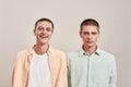 Portrait of two young caucasian men, twin brothers looking at camera with different face expressions while posing Royalty Free Stock Photo