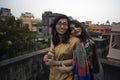 Portrait of two young Indian brunette girls/sisters/friends with traditional wear sari having fun on a rooftop Royalty Free Stock Photo