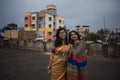 Portrait of two young Indian brunette girls/sisters/friends with traditional wear sari having fun on a rooftop Royalty Free Stock Photo
