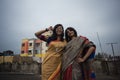 Portrait of two young Indian brunette girls/sisters/friends with traditional wear sari having fun on a rooftop Royalty Free Stock Photo