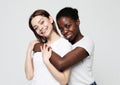 Portrait of two young multiracial women standing together and smiling at camera Royalty Free Stock Photo