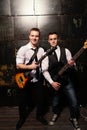 Portrait of Two young musicians with guitar on black background Royalty Free Stock Photo