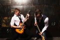 Portrait of Two young musicians with guitar on black background Royalty Free Stock Photo