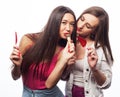 Portrait of two young pretty hipster girls holding candys.