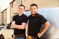 Portrait of two young tradesmen by their van