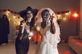 Portrait of two young women dressed in Halloween costumes of Witch and Dead Bride