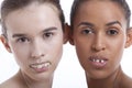 Portrait of two young women with fake teeth against white background