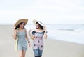 Portrait of two young women friends laughing and walking on the beach Royalty Free Stock Photo