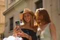 Portrait of two young women looking at the cell phone of one of them laughing Royalty Free Stock Photo