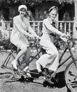 Portrait of two young women sitting on a tandem bicycle Royalty Free Stock Photo