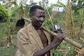 Portrait Ugandan farmer with hoe, portable radio