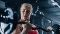 Portrait of an Uncompromising Young Woman Training with Heavy Barbell Exercise in a Dark Gym. A Royalty Free Stock Photo