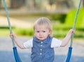 Portrait of unhappy baby sitting on swing Royalty Free Stock Photo