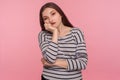 Portrait of unhappy bored woman in striped sweatshirt leaning on hand and expressing disinterest apathy