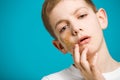 Portrait of unhappy boy with adhesive plaster on his ch