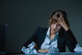 Portrait of unhappy and depressed business woman working overtime in office and having a headache from emotional stress. Symbol of Royalty Free Stock Photo