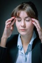 Portrait of unhappy and depressed business woman working overtime in office and having a headache from emotional stress. Vertical Royalty Free Stock Photo
